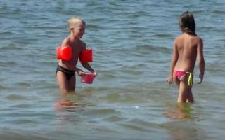 Boy blond wearing black speedo in beach with a girl (2)