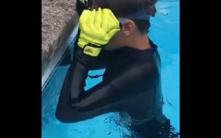 Boy in wetsuit dives in pool