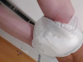 Diaper teen after an enema, red spanked butt at one side