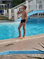 A young boy in black swimming trunks